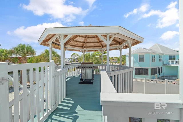 wooden terrace with a gazebo and a grill