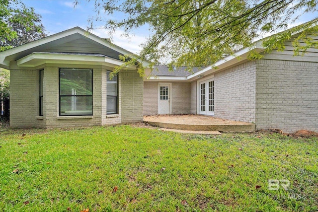 rear view of property featuring a yard and a patio area