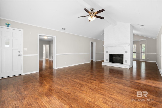 unfurnished living room featuring a brick fireplace, ornamental molding, lofted ceiling with beams, and dark hardwood / wood-style flooring