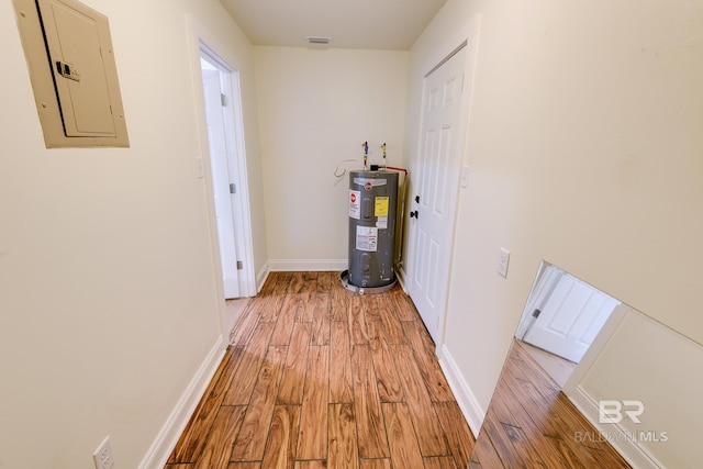 hall with light hardwood / wood-style floors and water heater