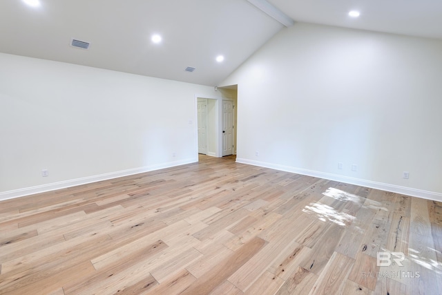 empty room featuring beam ceiling, high vaulted ceiling, and light wood-type flooring