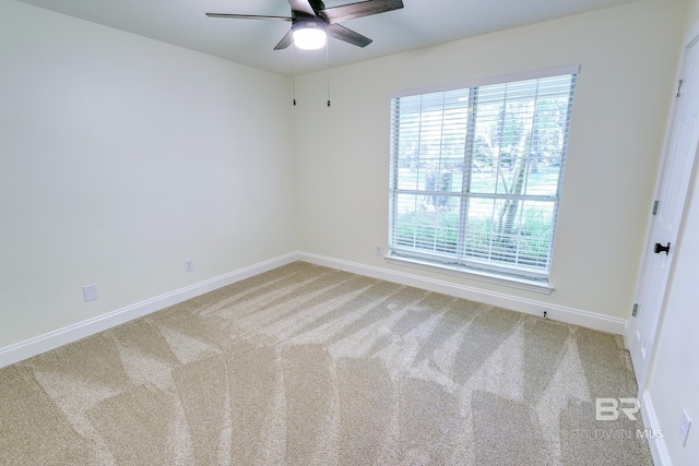 carpeted spare room with ceiling fan