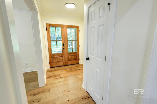 entryway featuring ornamental molding, light hardwood / wood-style flooring, and french doors