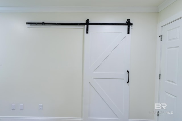 details with a barn door and ornamental molding