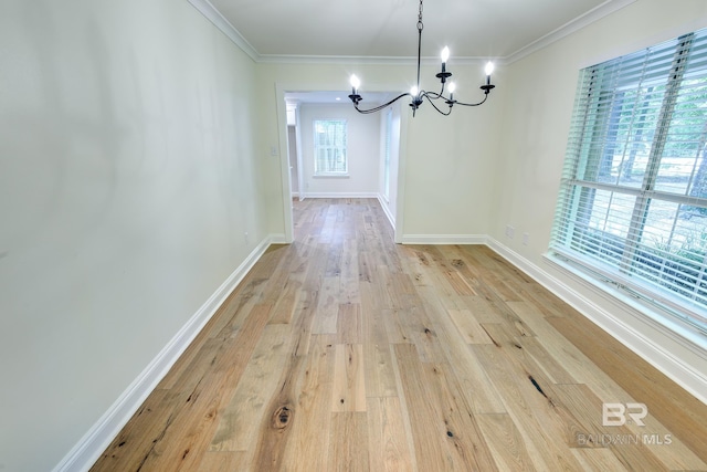 unfurnished dining area featuring a chandelier, light hardwood / wood-style flooring, and ornamental molding