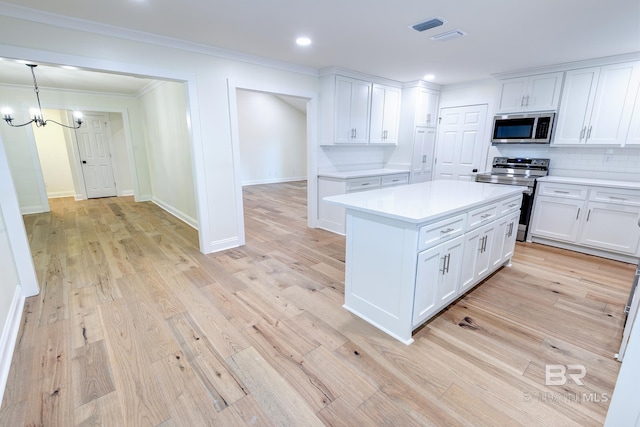 kitchen with light wood-type flooring, white cabinets, range with electric stovetop, decorative light fixtures, and tasteful backsplash