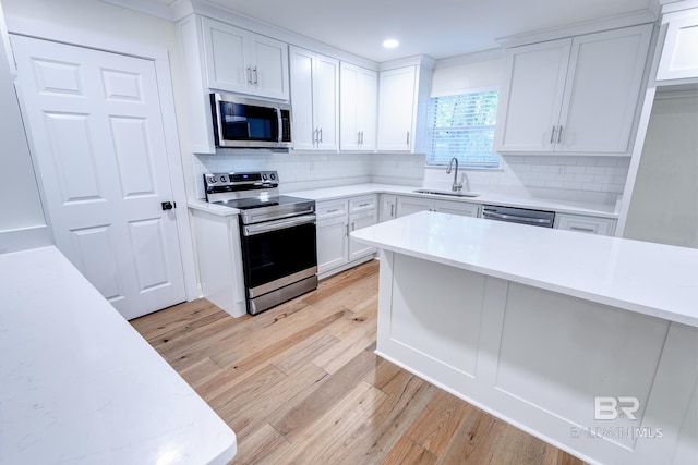 kitchen featuring light hardwood / wood-style floors, sink, backsplash, and stainless steel appliances