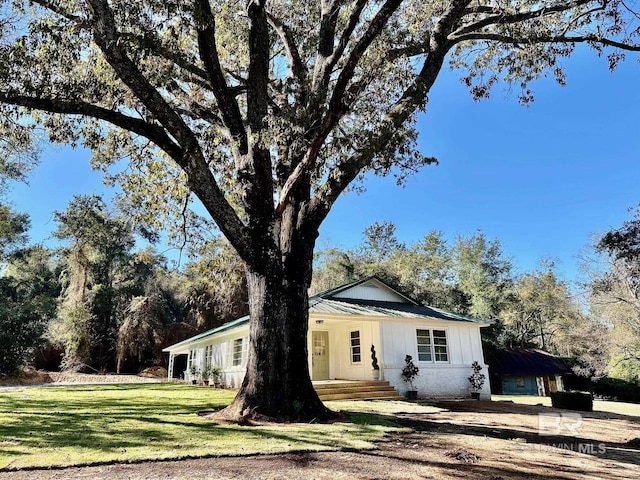 exterior space featuring covered porch and a front yard