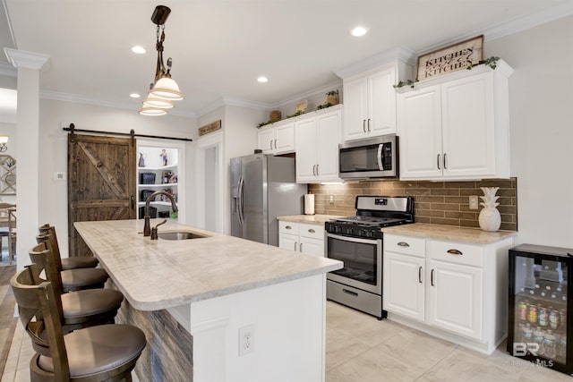 kitchen with wine cooler, sink, white cabinetry, stainless steel appliances, and a barn door