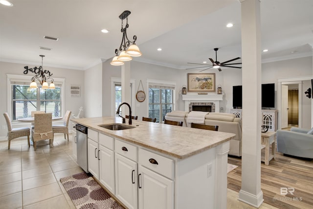 kitchen with pendant lighting, sink, white cabinetry, a center island with sink, and stainless steel dishwasher