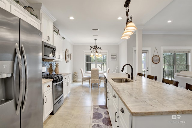 kitchen featuring pendant lighting, appliances with stainless steel finishes, sink, and a center island with sink