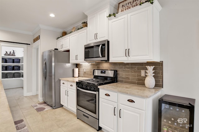 kitchen featuring wine cooler, stainless steel appliances, white cabinets, and light tile patterned flooring