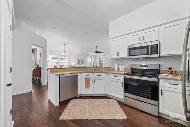 kitchen featuring stainless steel appliances, tasteful backsplash, white cabinets, and kitchen peninsula