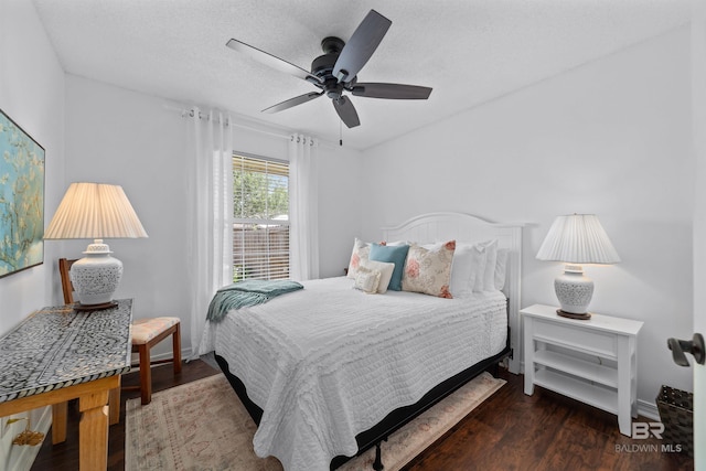 bedroom with ceiling fan, dark hardwood / wood-style floors, and a textured ceiling