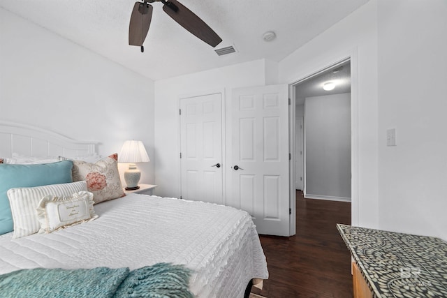 bedroom featuring dark wood-type flooring, ceiling fan, and a closet