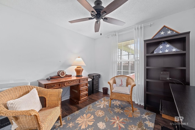 living area featuring ceiling fan, dark hardwood / wood-style flooring, and a textured ceiling