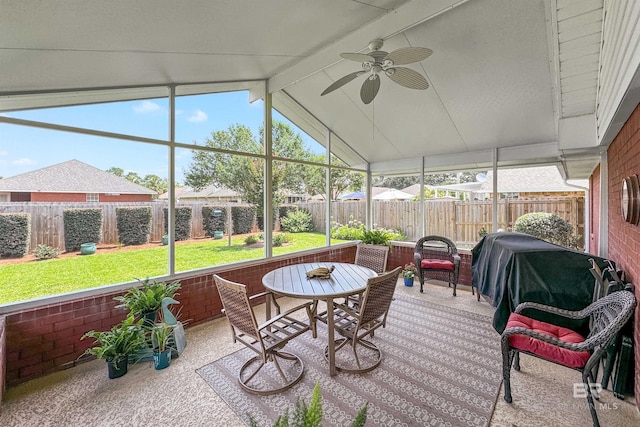 sunroom with ceiling fan and vaulted ceiling with beams