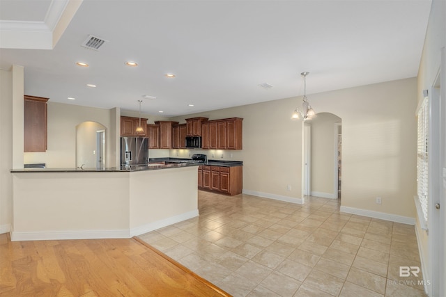 kitchen featuring an inviting chandelier, decorative light fixtures, black appliances, and light hardwood / wood-style flooring