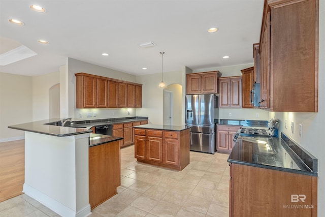 kitchen with a kitchen island, sink, kitchen peninsula, hanging light fixtures, and appliances with stainless steel finishes