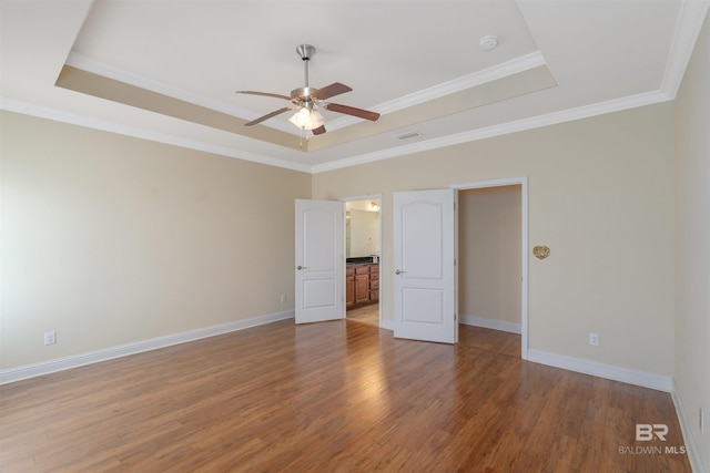 unfurnished bedroom with hardwood / wood-style flooring, crown molding, ceiling fan, and a raised ceiling