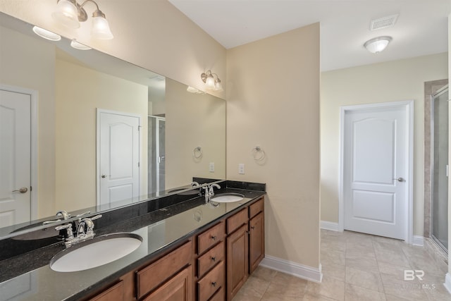 bathroom with tile patterned flooring, a shower with door, and vanity