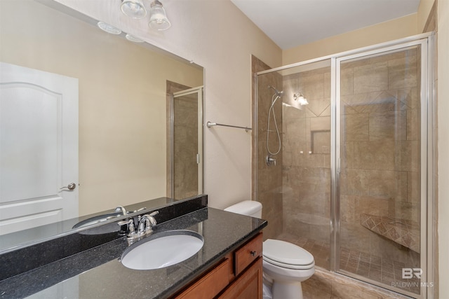 bathroom featuring a shower with shower door, vanity, and toilet