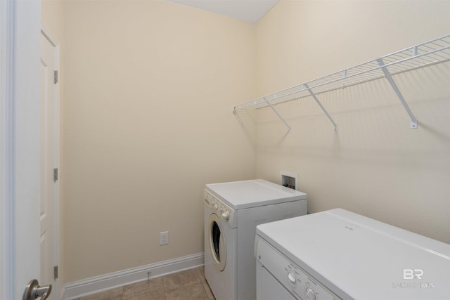 laundry area with light tile patterned flooring and washing machine and clothes dryer