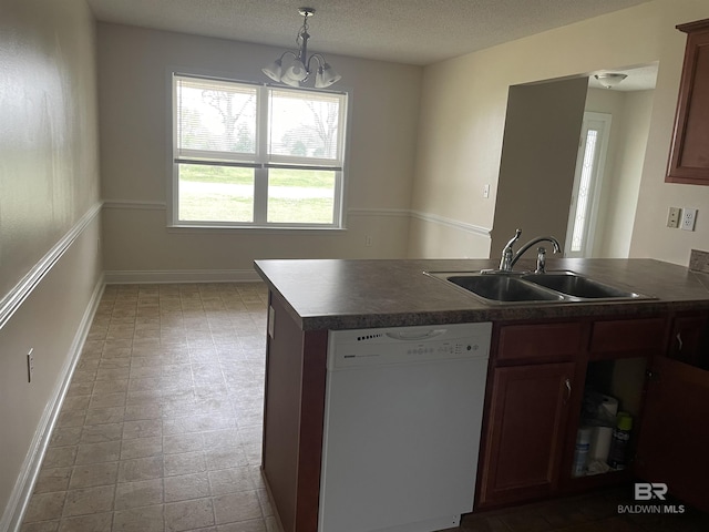 kitchen featuring a textured ceiling, white dishwasher, a peninsula, a sink, and dark countertops