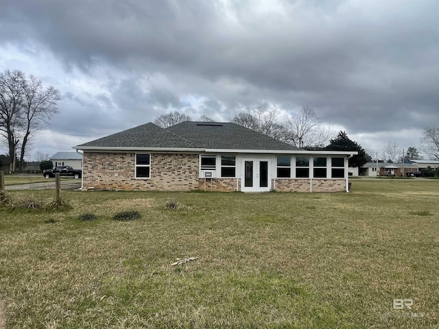 back of house with a yard, french doors, a shingled roof, and brick siding