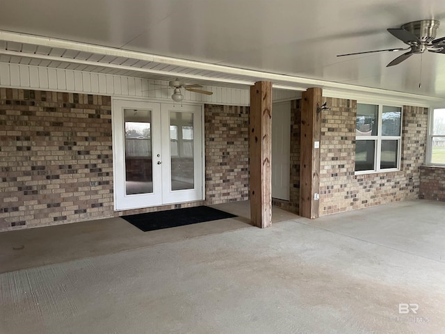 entrance to property featuring a ceiling fan, french doors, and brick siding