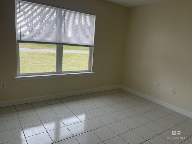 unfurnished room featuring baseboards and light tile patterned floors