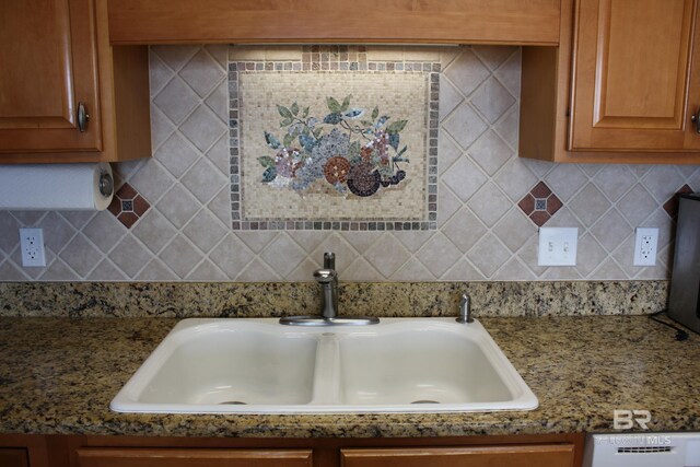 details featuring light stone countertops, decorative backsplash, and sink