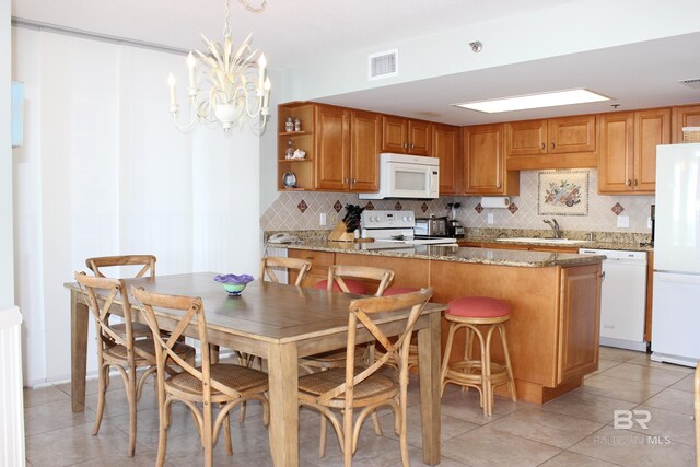 kitchen with sink, hanging light fixtures, kitchen peninsula, white appliances, and decorative backsplash