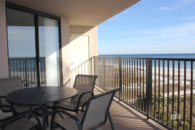 balcony with a water view and a view of the beach