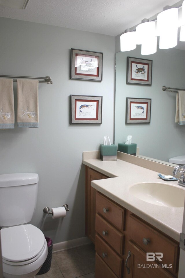 bathroom featuring tile patterned floors, vanity, a textured ceiling, and toilet