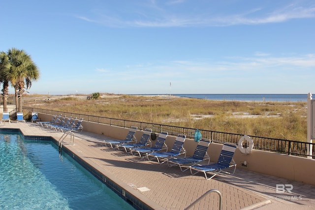 view of swimming pool with a patio area and a water view