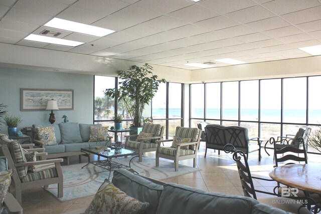 tiled living room with a water view and a beach view