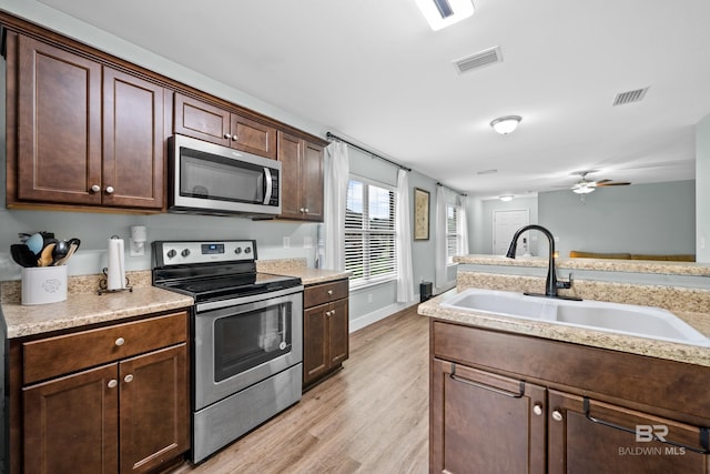 3931 Langley Ave, Foley, AL 36535 - kitchen with stainless steel appliances, light wood-style flooring, light countertops, a ceiling fan, and dark brown cabinetry