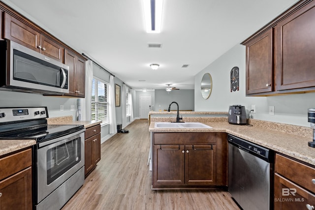3931 Langley Ave, Foley, AL 36535 - kitchen featuring stainless steel appliances, a peninsula, light wood finished floors, ceiling fan, and light countertops
