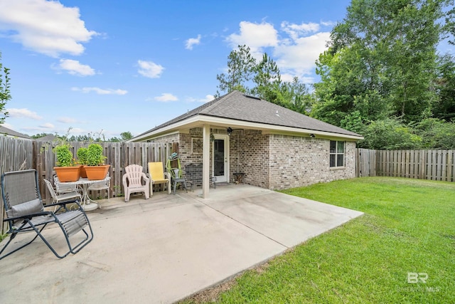 3931 Langley Ave, Foley, AL 36535 - rear view of house featuring a patio area, brick siding, a fenced backyard, and a shingled roof