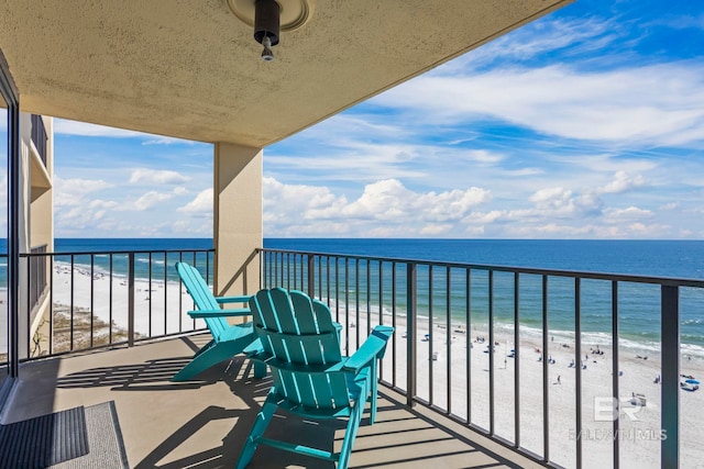 balcony with a water view and a beach view