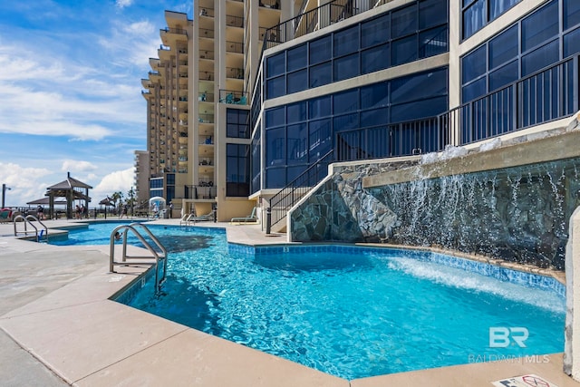 view of swimming pool featuring a gazebo, a patio area, and pool water feature