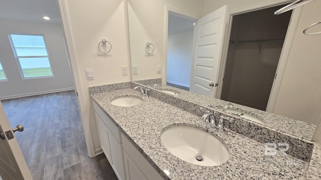 full bathroom featuring a spacious closet, wood finished floors, and a sink