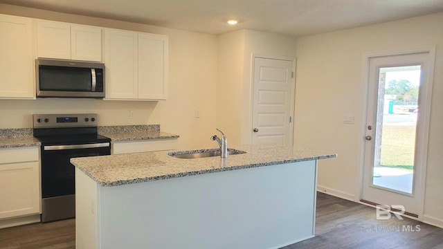 kitchen featuring light stone counters, appliances with stainless steel finishes, dark wood-type flooring, and a sink