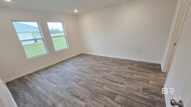 empty room with dark wood-style floors, recessed lighting, and baseboards