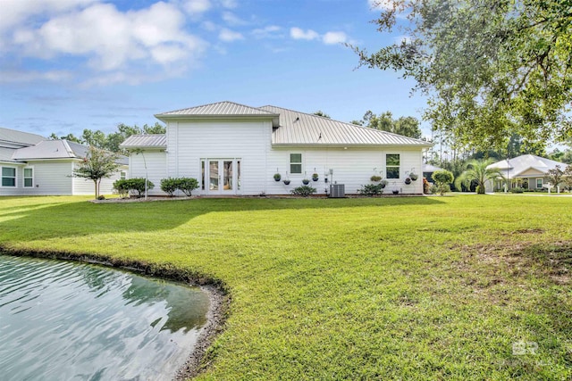 back of property featuring a yard, french doors, metal roof, and central AC