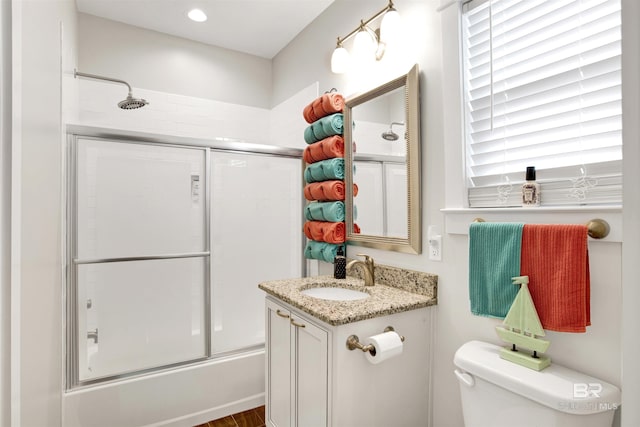 full bathroom featuring vanity, toilet, and enclosed tub / shower combo