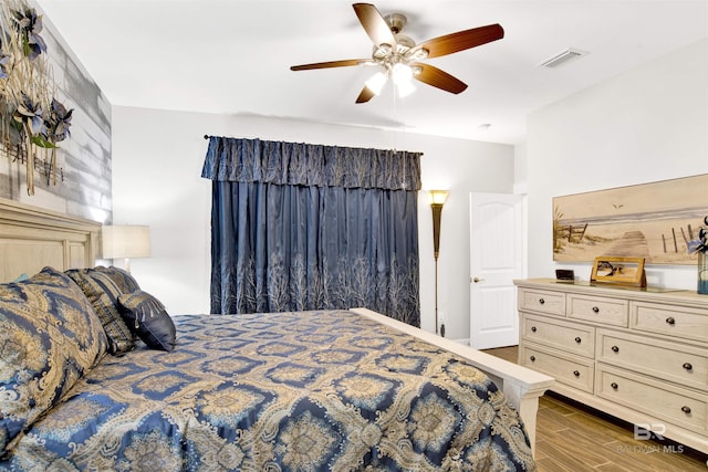 bedroom with visible vents, ceiling fan, and wood finished floors