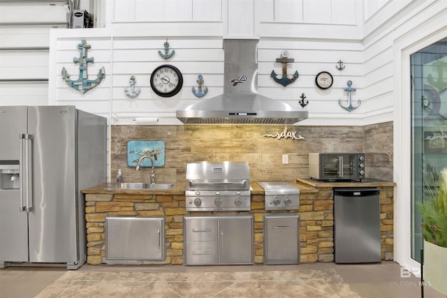 kitchen featuring fridge, island exhaust hood, stainless steel refrigerator with ice dispenser, and a sink