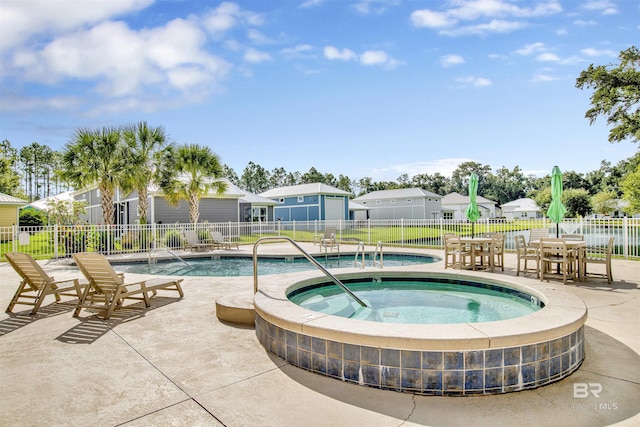 community pool featuring a patio, a community hot tub, and fence